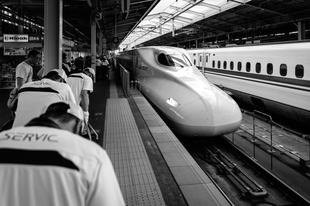 Workers salute the shinkansen entering the Osaka station.