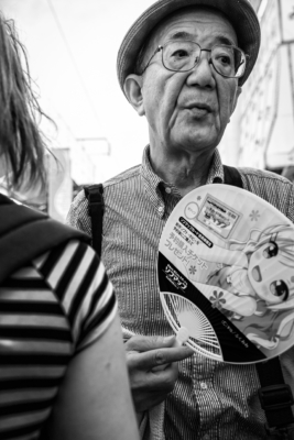An old man with a cute fan in Ameyoko shopping street, Ueno, Tokyo, Japan.
