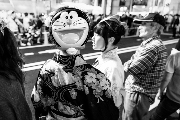A young woman in yukata wearing a Doraemon mask in the back of her head during the Toukasan Yukata Festival in Hiroshima, Japan.